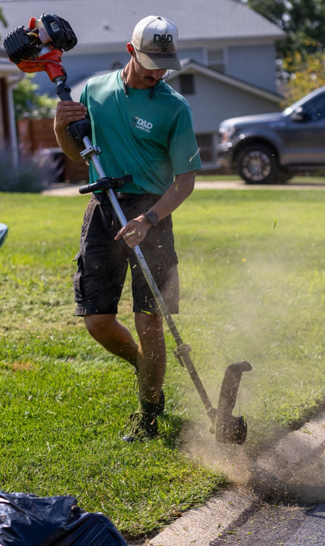 D&D Landscaping crew member mowing a lawn