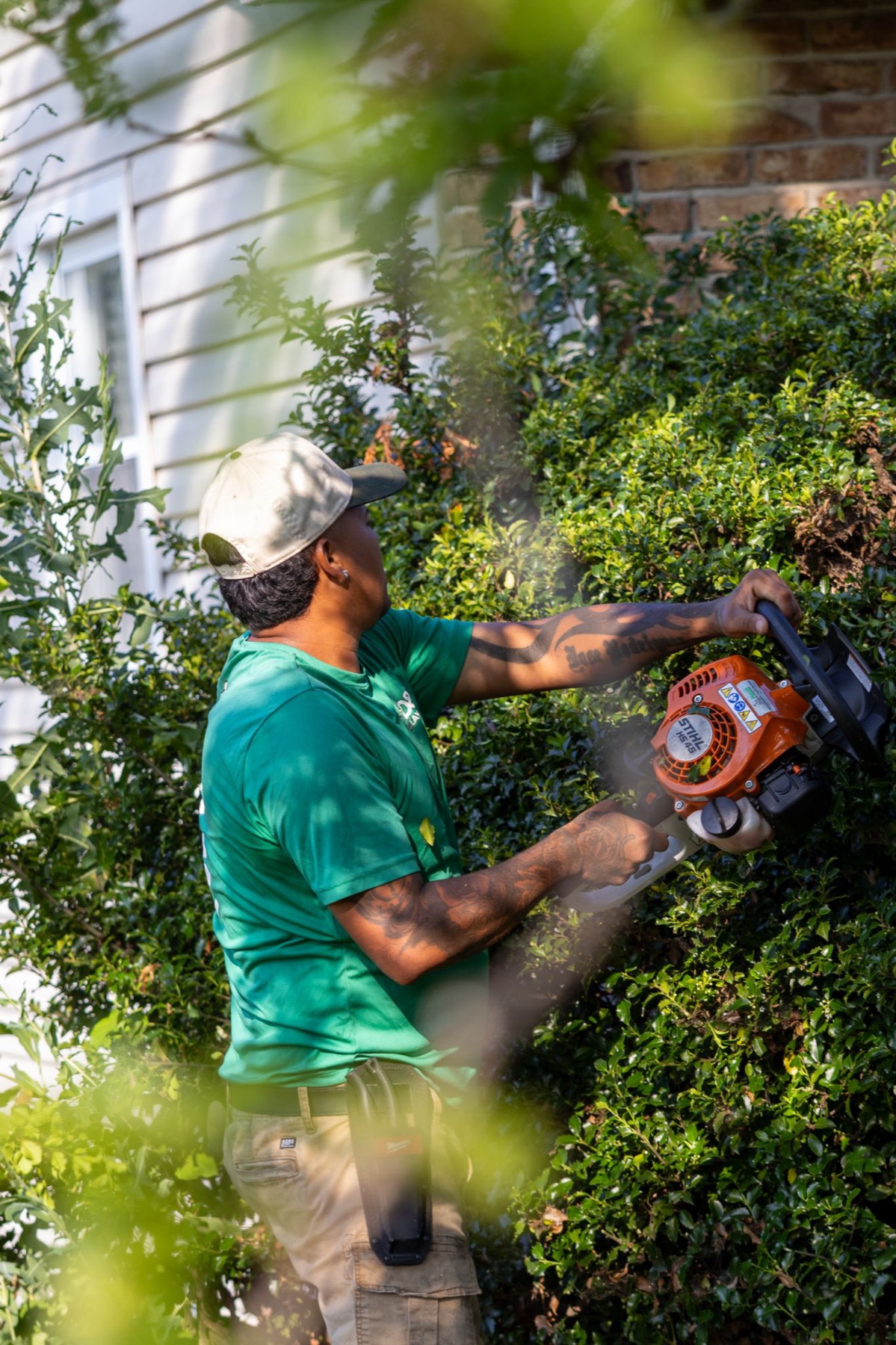 Landscaper trimming a hedge